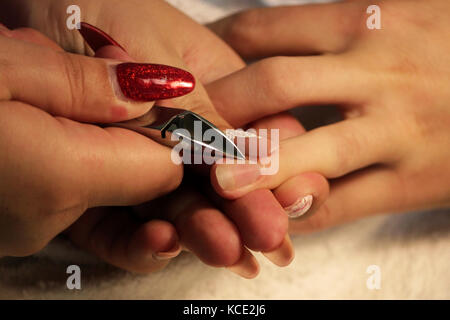 Manicurist a corsi di formazione mostra agli studenti come gestire le unghie con l aiuto del tronchese cuticole prima di applicare la gomma lacca Foto Stock