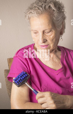 Anziani self frizionando il corpo per il dolore Foto Stock