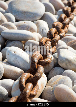 Rusty catena di ancoraggio pietre ghiaia Foto Stock