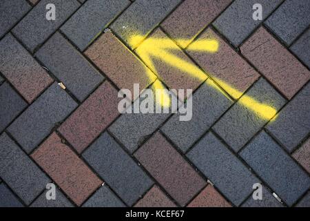 Un verniciato a spruzzo freccia sul marciapiede Foto Stock