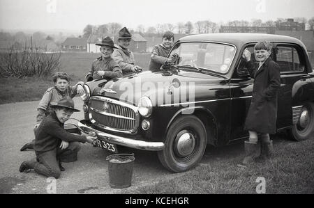 Anni '60, storico, Inghilterra, Regno Unito, ragazzo scouts pulizia di una macchina Hillman Minx durante Bob-a-lavoro settimana, una volta all'anno settimana quando il ragazzo locale scouts farebbe lavori dispari per una bob - il vecchio nome per una shiling. Foto Stock