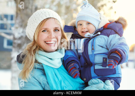 Felice la madre e il bambino in winter park Foto Stock