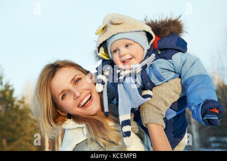 Felice la madre e il bambino in winter park Foto Stock