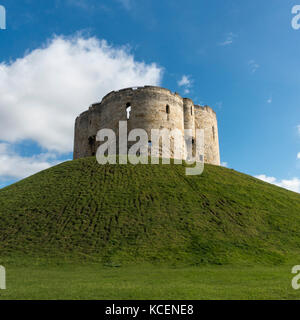 Soleggiata giornata autunnale con un luminoso cielo blu, oltre il ben noto punto di riferimento storico, la Torre di Clifford alta sul tumulo erboso - York, North Yorkshire, Inghilterra, Regno Unito. Foto Stock