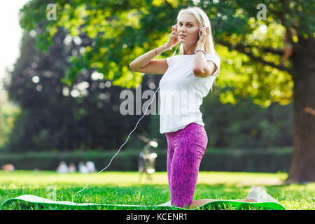 Foto di sport donna che indossa le cuffie Foto Stock