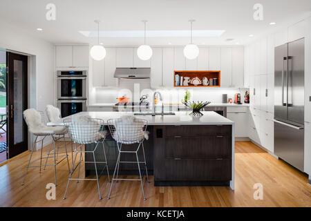 Cucina con isola adiacente alla sala da pranzo e soggiorno. Bruning Owen House, Chevy Chase, Stati Uniti. Architetto: Lou Balodemas architetti, 2015. Foto Stock