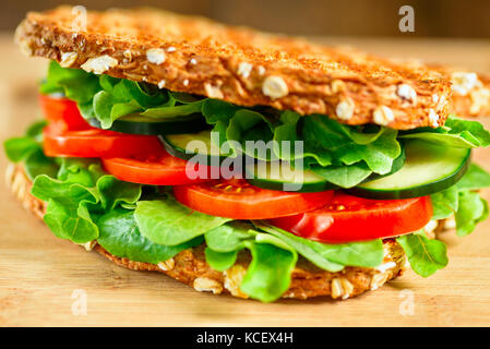 Sana vegano grigliate sandwich made di germogliato pane organico, pomodoro, cetriolo, spinaci e rucola. messa a fuoco selettiva Foto Stock