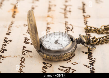 Vintage orologio da tasca su sfondo manoscritto Foto Stock