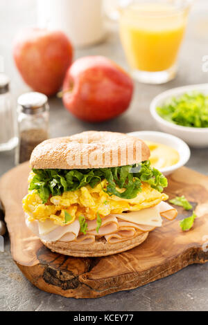 La colazione bagel con uova strapazzate e Turchia Foto Stock