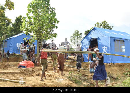 (171004) -- DACCA, 4 ottobre 2017 (Xinhua) -- le persone camminano vicino alle tende di soccorso cinesi in un campo nel distretto di Cox's Bazaar, Bangladesh, il 3 ottobre 2017. La Cina ha recentemente inviato rifornimenti per i rifugiati rohingya in Bangladesh. (Xinhua/Jibon Ahsan) (zcc) Foto Stock