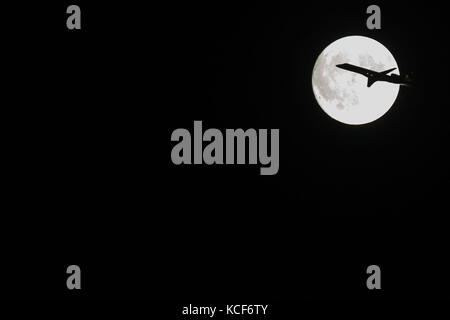 New York, Stati Uniti. 04th ottobre 2017. Gli aerei passano davanti alla luna piena sopra il credito di New York: Pressa fotografica del Brasile/notizie dal vivo di Alamy Foto Stock