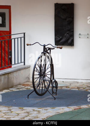 La vecchia bicicletta con uno grande e uno piccolo ruota in cantiere nella città vecchia di Tallinn Foto Stock