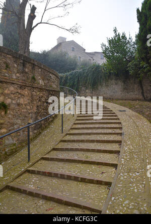 Spoleto (Italia) - un nebbioso giorno cadono nel suggestivo borgo medievale nella regione Umbria. La fitta nebbia crea un atmosfera suggestiva con raggi solari Foto Stock