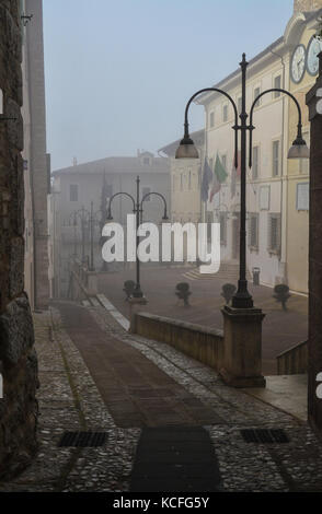 Spoleto (Italia) - un nebbioso giorno cadono nel suggestivo borgo medievale nella regione Umbria. La fitta nebbia crea un atmosfera suggestiva con raggi solari Foto Stock