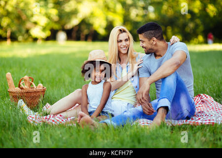 Immagine della coppia adorabile con la loro figlia avente picnic Foto Stock