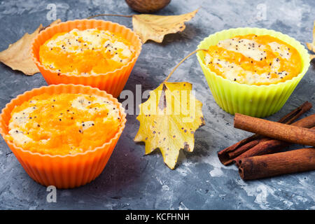 Muffin di zucca su uno sfondo con foglie di autunno Foto Stock