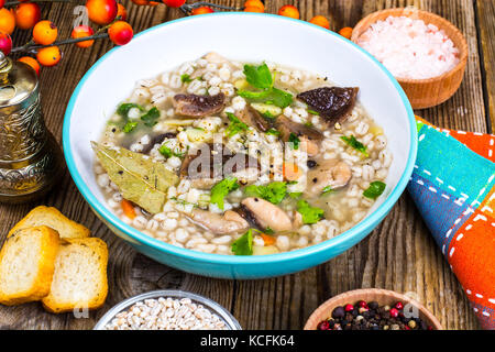 Zuppa vegetariana con funghi e farro per pranzo sul tavolo di legno Foto Stock