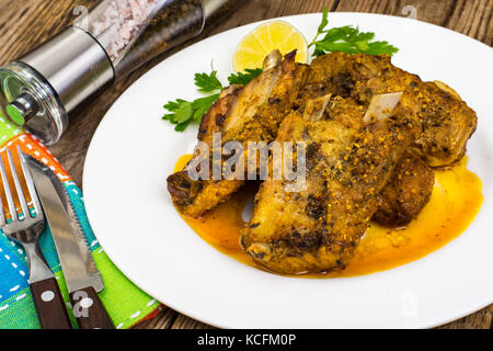 Piccante costolette di carne in salsa di senape sul tavolo di legno Foto Stock