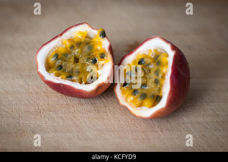 Passione fresca frutta tagliata a metà su un blocco di macellaio Foto Stock