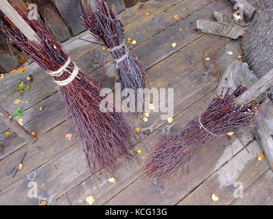 Tre streghe broomsticks sul pavimento in legno della caduta. mantenimento della pulizia in casa e cantiere, vintage voce per la pulizia. Foto Stock