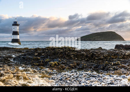 Sunrise a penmon faro (trwyn du faro), penmon, isola di Anglesey, Galles del Nord, Regno Unito Foto Stock