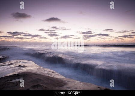 Una lunga esposizione colpo di rocce e acqua di seta intorno al tramonto a la Jolla costa della California. Foto Stock