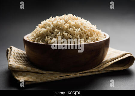 Foto di stock di indiani marrone basmati integrali di riso cotto e riso crudo, servita in una ciotola messa a fuoco selettiva Foto Stock