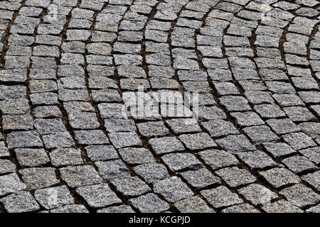 Un close-up foto di una parte di una pavimentazione stradale pavimentata con ciottoli. Il pavimento è realizzato in forma di un semicerchio, come si vede nella foto Foto Stock