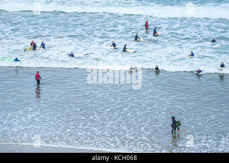 Navigare nel Regno Unito. Giovani godendo di imparare a fare surf con guida da istruttori di surf. Foto Stock