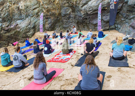 Un gruppo di donne a praticare yoga su una spiaggia - Surf Betty's Festival un festival che si tiene a Newquay emancipazione delle donne attraverso il fitness e surf. Foto Stock