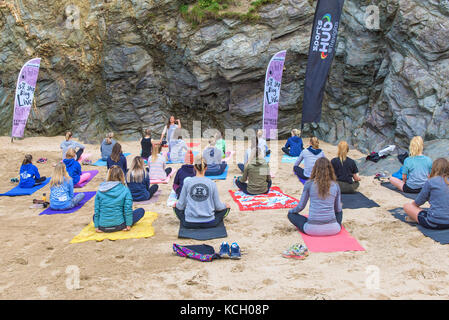 Un gruppo di donne a praticare yoga su una spiaggia - Surf Betty's Festival un festival che si tiene a Newquay emancipazione delle donne attraverso il fitness e surf. Foto Stock