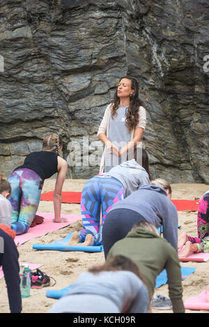 Un womens' gruppo a praticare yoga su una spiaggia - Surf Betty's Festival a womens' festival tenutosi a Newquay emancipazione delle donne attraverso il fitness e surf. Foto Stock