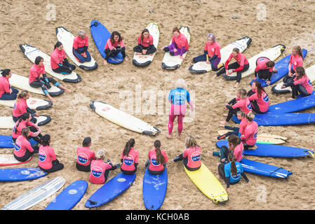 Principianti per partecipare ad una Lezione di Surf - Surf Betty's Festival un festival che si tiene a Newquay per aiutare le donne attraverso il surf e il fitness. La Cornovaglia. Foto Stock
