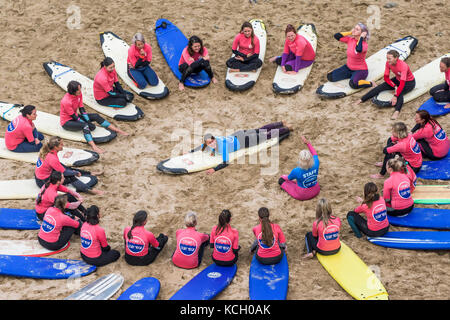 Principianti per partecipare ad una Lezione di Surf - Surf Betty's Festival un festival che si tiene a Newquay per aiutare le donne attraverso il surf e il fitness. La Cornovaglia. Foto Stock