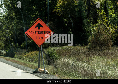 Orange lavoratore edile segno a una strada in lontananza sulla Trans Canada Foto Stock