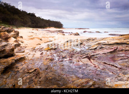 Paesaggio oceanico australiano all'alba con rocce bagnate Isola di Stradbroke Foto Stock