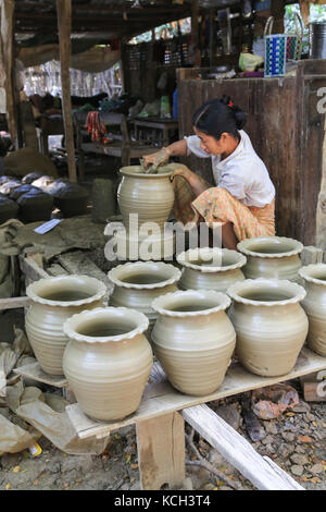 Una donna è formare il bordo superiore di una pentola lei sta lavorando su in Yandabo villaggio sul fiume Irrawaddy in Myanmar (Birmania). Foto Stock