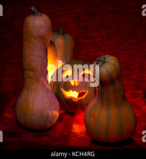 Halloween, male candele zucca gloom sul rosso Foto Stock