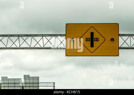 Attraversamento ferroviario attenzione attenzione segno luci nella parte anteriore del cielo molto nuvoloso in Canada Foto Stock