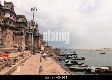 Varanasi, India - 14 marzo 2016: immagine orizzontale delle scale di munshi ghat e molte imbarcazioni al fiume Gange nella città di Varanasi in India Foto Stock