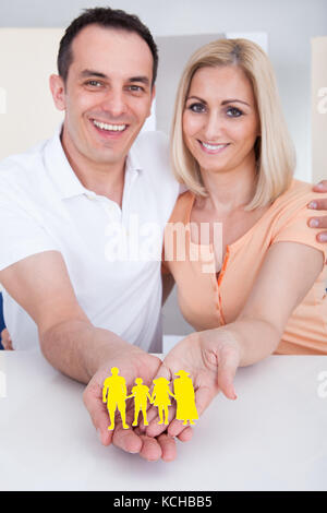 Ritratto di coppia felice famiglia holding figura cut-out Foto Stock