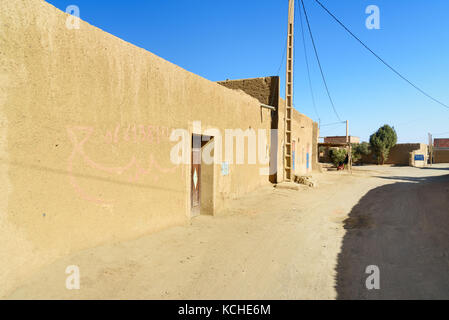 Merzouga, Marocco - Jan 6, 2017: Sulla strada nel villaggio di Merzouga. Due uomini marocchini in bianco djellaba talk su strada Foto Stock