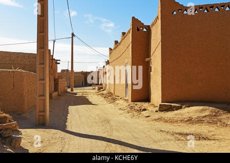 Merzouga, Marocco - Jan 6, 2017: Sulla strada nel villaggio di Merzouga. Due uomini marocchini in bianco djellaba talk su strada Foto Stock