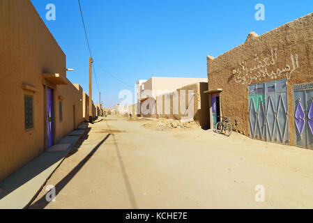 Merzouga, Marocco - Jan 6, 2017: Sulla strada nel villaggio di Merzouga. Due uomini marocchini in bianco djellaba talk su strada Foto Stock