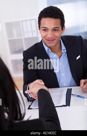 Imprenditore stringono le mani con la donna in ufficio Foto Stock