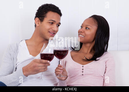Ritratto di giovane africano giovane tostatura di vino rosso Foto Stock