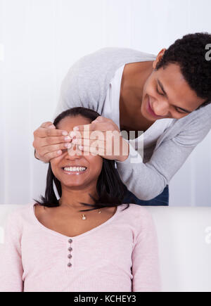 Ritratto di giovane uomo che copre gli occhi di donna Foto Stock