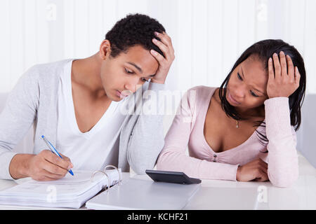 Ritratto di preoccupato giovane lavorando insieme su scrivania Foto Stock