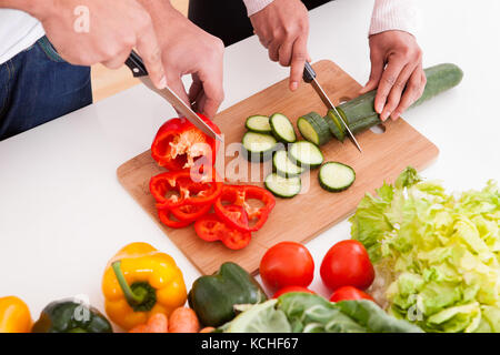 Ritratto di giovane tritare verdure in cucina Foto Stock