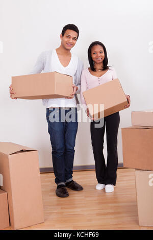 Ritratto di giovane coppia scatole porta in casa Foto Stock